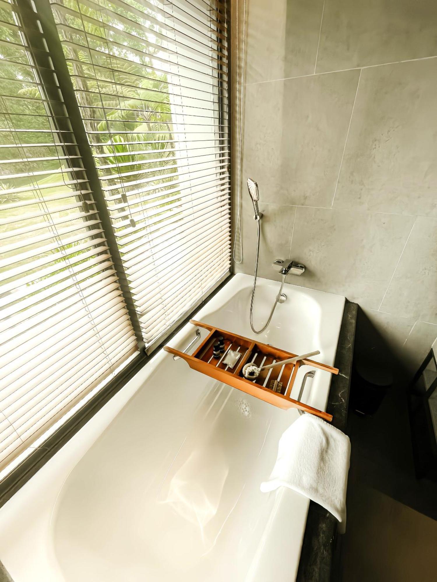 The Botanica Sanctuary Hotel Puncak Quarto foto A bathtub with a shower